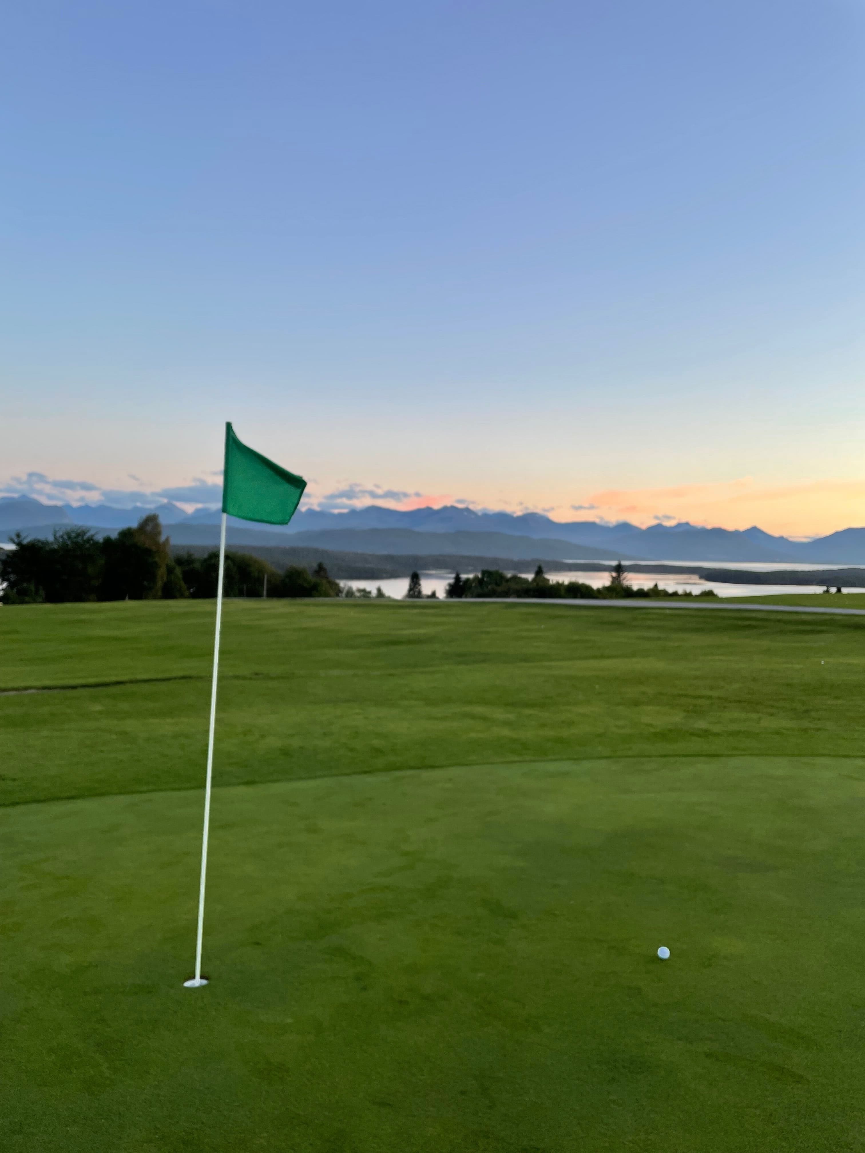 Green med flagg ved solnedgang